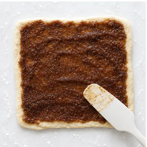 Step 3: Spreading the warm cinnamon-brown sugar filling over the dough