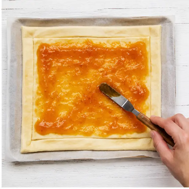 Step 2: Spreading apricot jam on pastry
