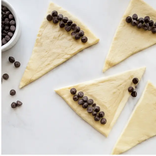 Step 2: Adding chocolate chips to dough triangles