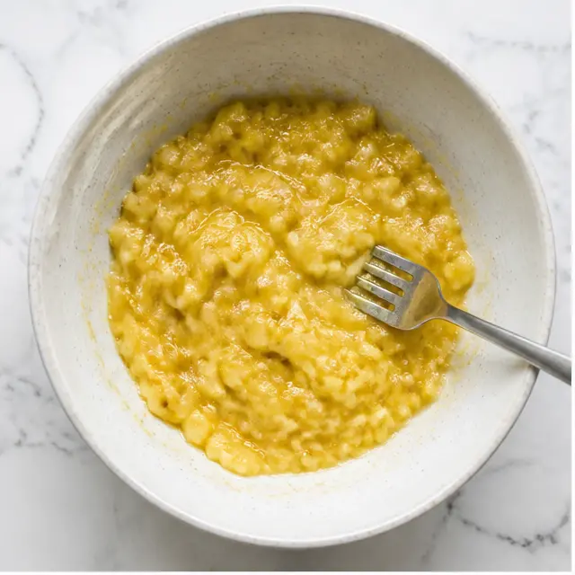 Step 1: Mashing overripe bananas with a fork until fairly smooth
