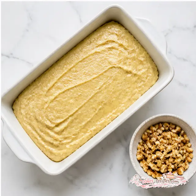 Step 4: Transferring thick batter to a prepared loaf pan and smoothing the top