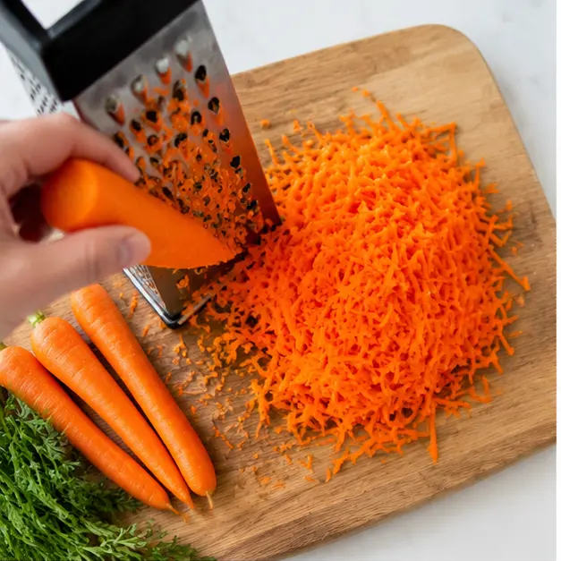 Grate fresh carrots on the large holes of a box grater