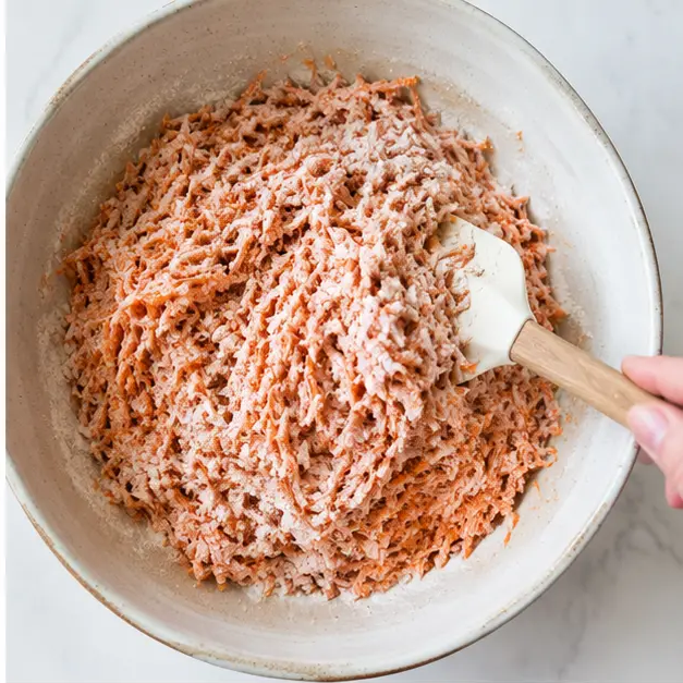 Toss the grated carrots with the flour mixture until fully coated