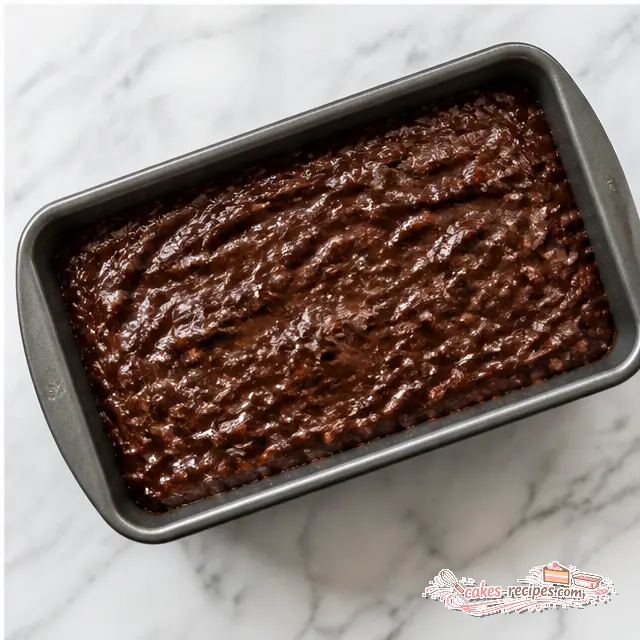 Pouring chocolate batter into a loaf pan