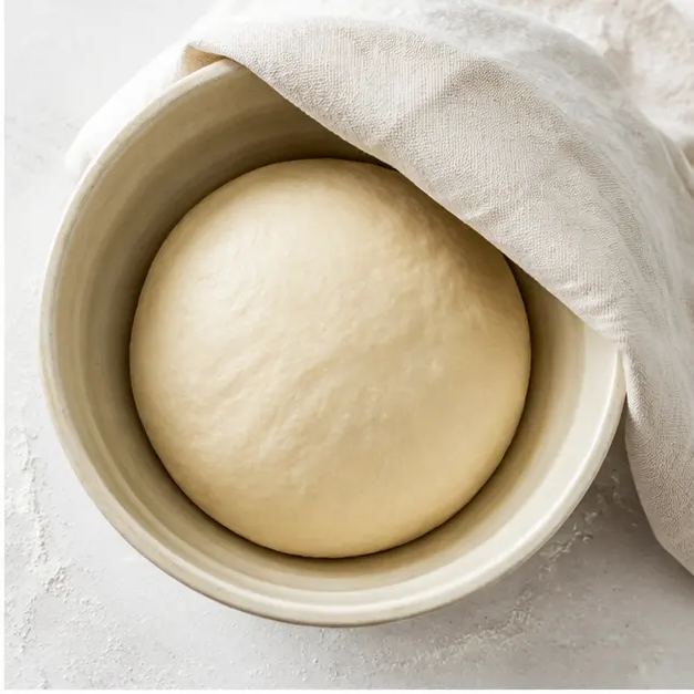 Step 2: Kneaded smooth dough ball rising in an oiled ceramic bowl