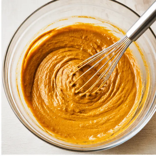 Step 2: Whisk wet ingredients including pumpkin puree and maple syrup into a smooth batter