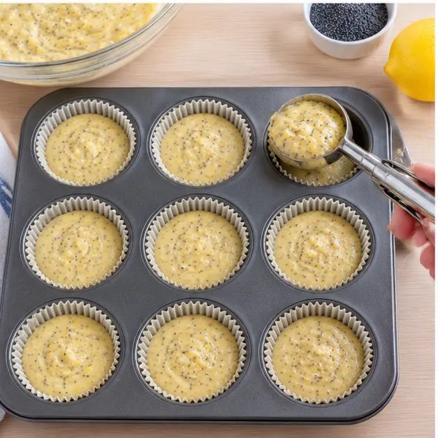 Scooping batter into lined muffin cups with a quarter-cup scoop