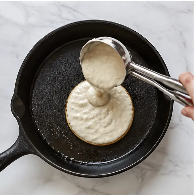 Step 3: Pouring batter into a low-heat cast iron skillet until bubbles pop on the surface